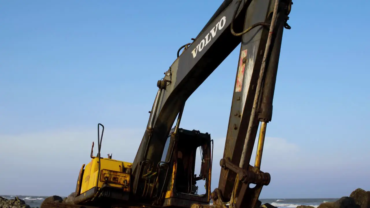 Abandoned Yellow Digger on Rocky Beach Thailand