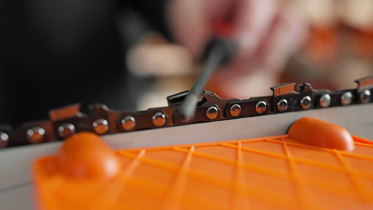 Sharpening a chainsaw chain in 30 degree angle close up