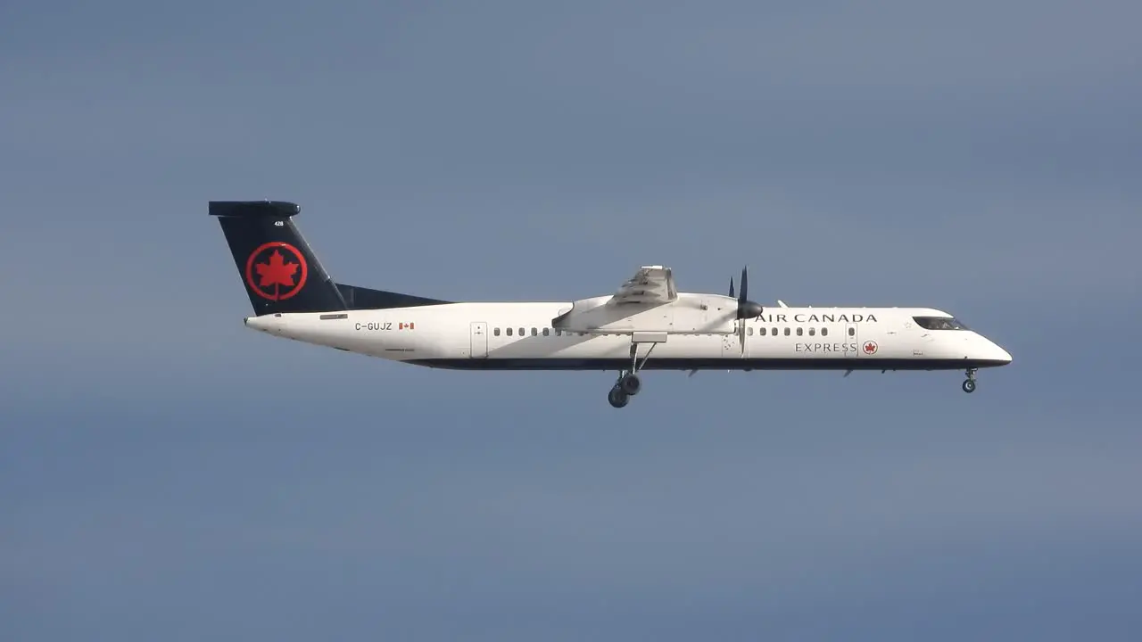 Air Canada Bombardier propeller airplane flying in blue sky sideways tracking