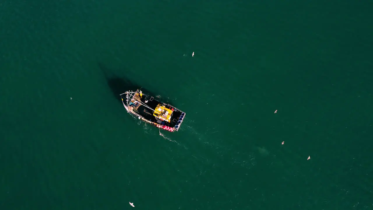 A birds eye view drone shot of a fishing boat off the coast of Devon Uk