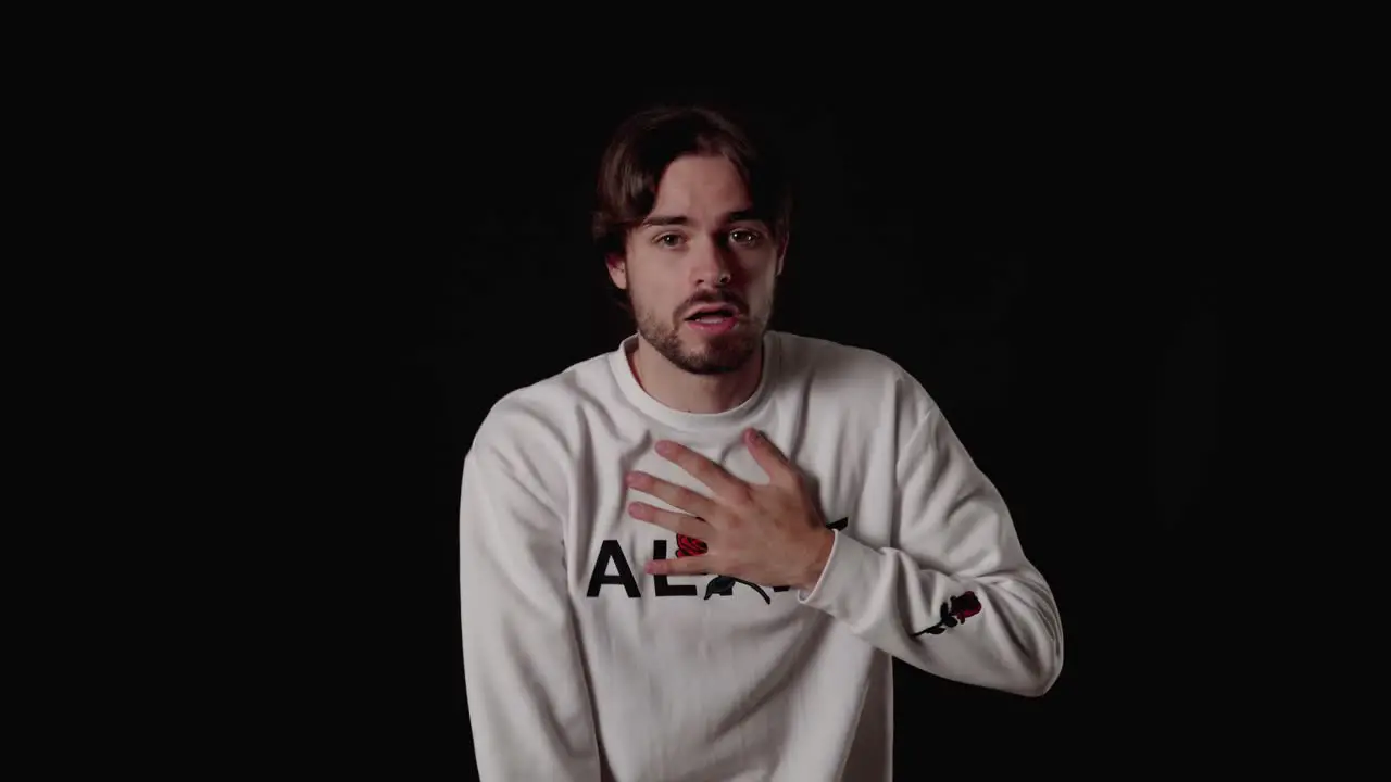 Trendy Young Man frightened gesture scared expression wide black background