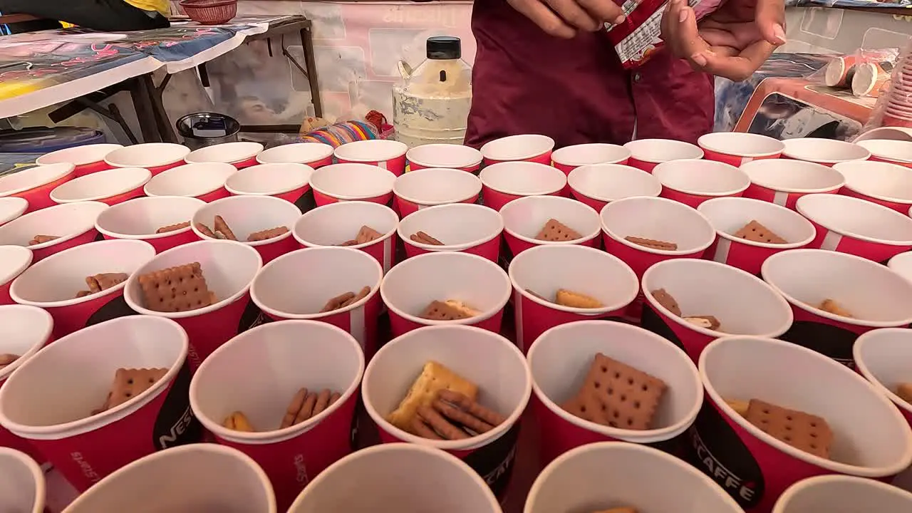 Frozen Ice Cold Biscuits Shopkeeper is filling Biscuits into cups