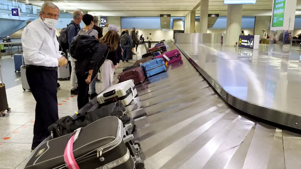 People picking up their bags at the airport carousel baggage claim