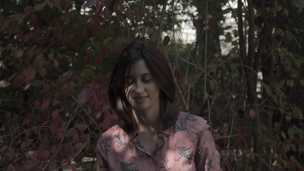 Young woman tossing up leaves in autumn slow motion head shot