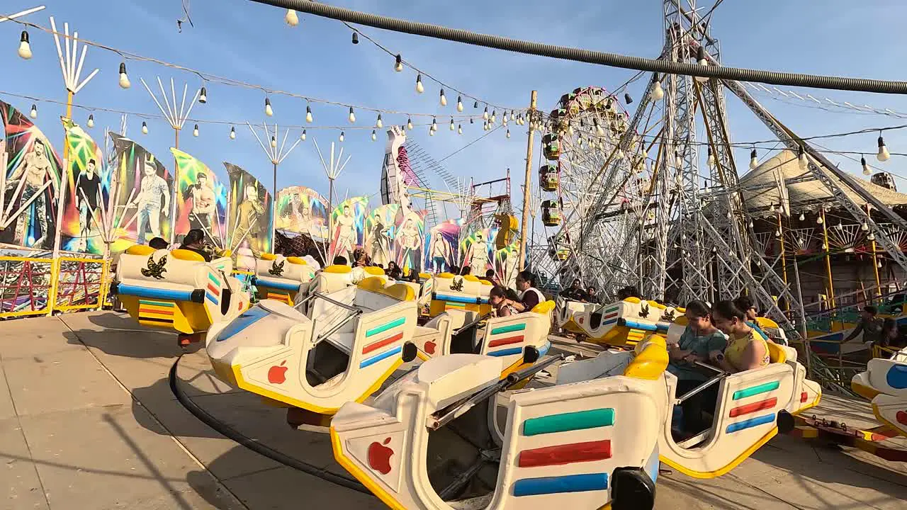 Wide Soot day time scene of a breaking dance ride in an amusement park with people enjoying it