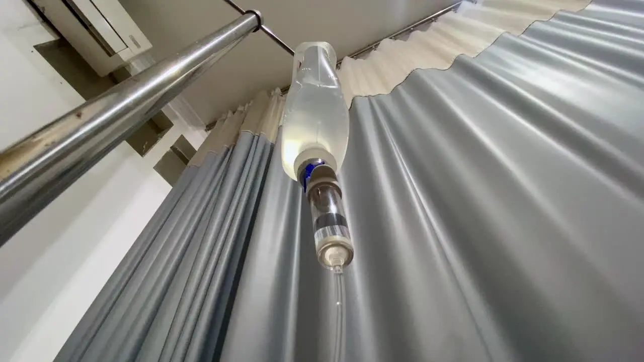 intravenous drip with a hospital curtain in the background Hospital room