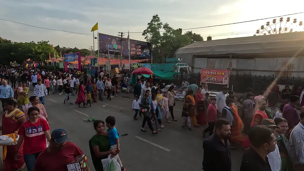 Scene taken from above thousands of people coming out of the amusement park at dusk