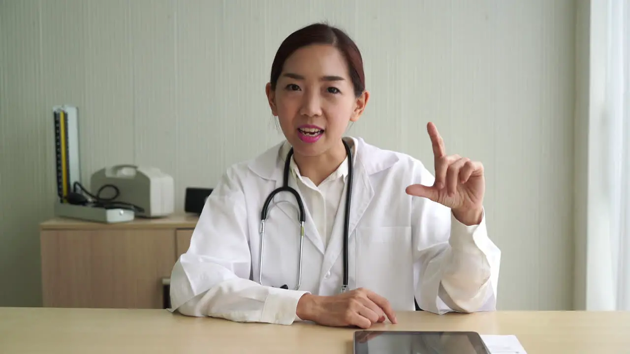 Asian female doctor talking in office