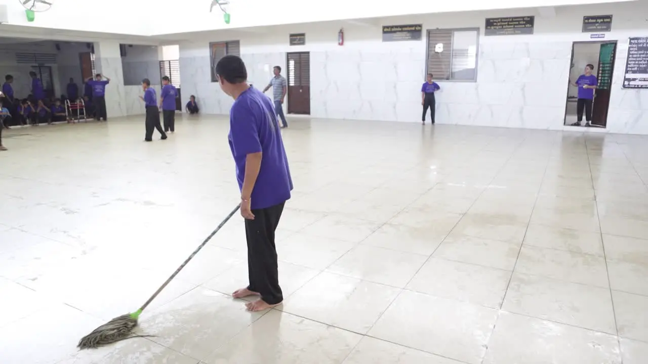 A mentally retarded woman cleans the NGO campus and defecates on the tiles