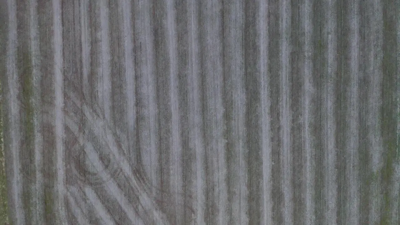 A top-down dolly aerial shot of a freshly mowed farm land plot where corn is grown in Frankfort Kentucky nearing sunset with a dark vibe