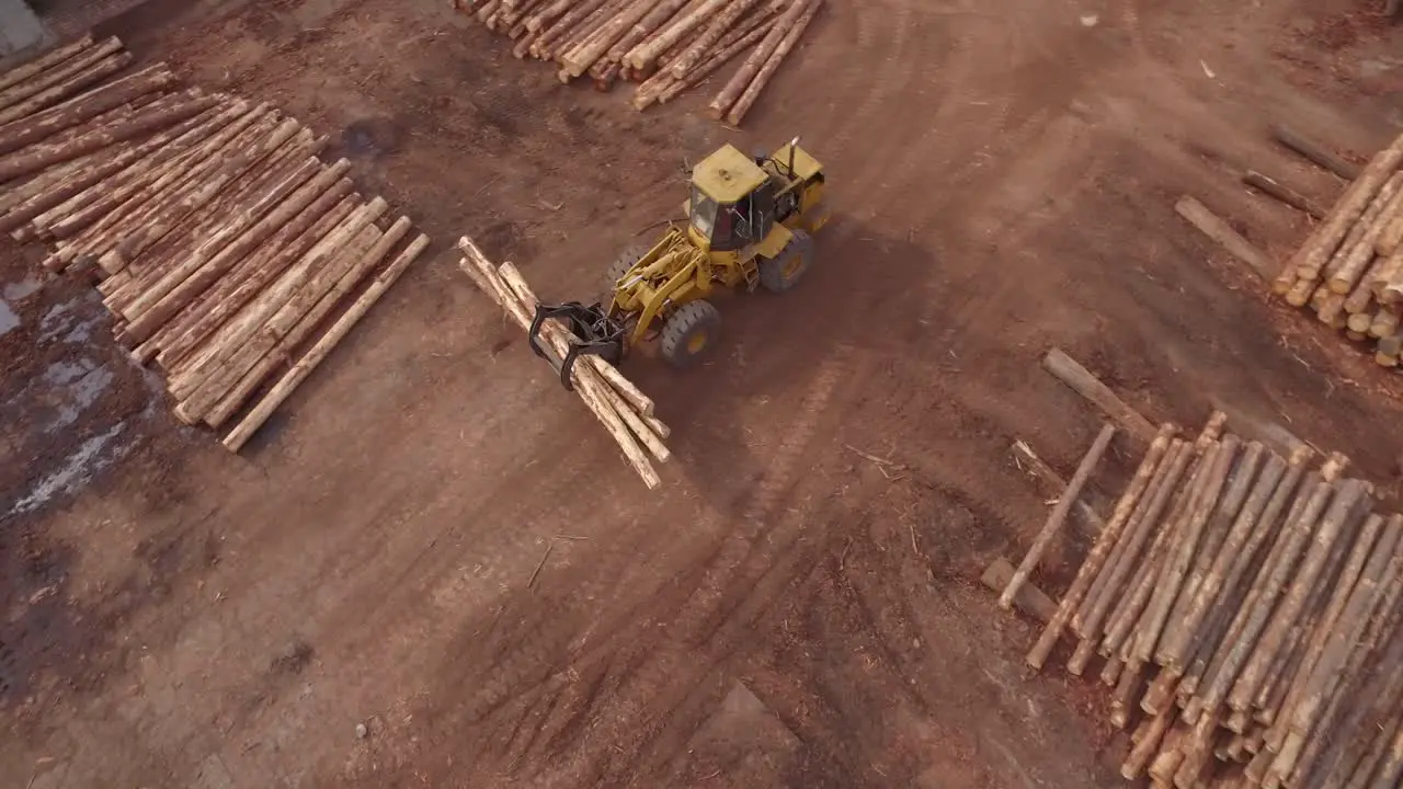 4K Aerial Shot Descending Towards and tracking Timber Logging Front loader Vehicle