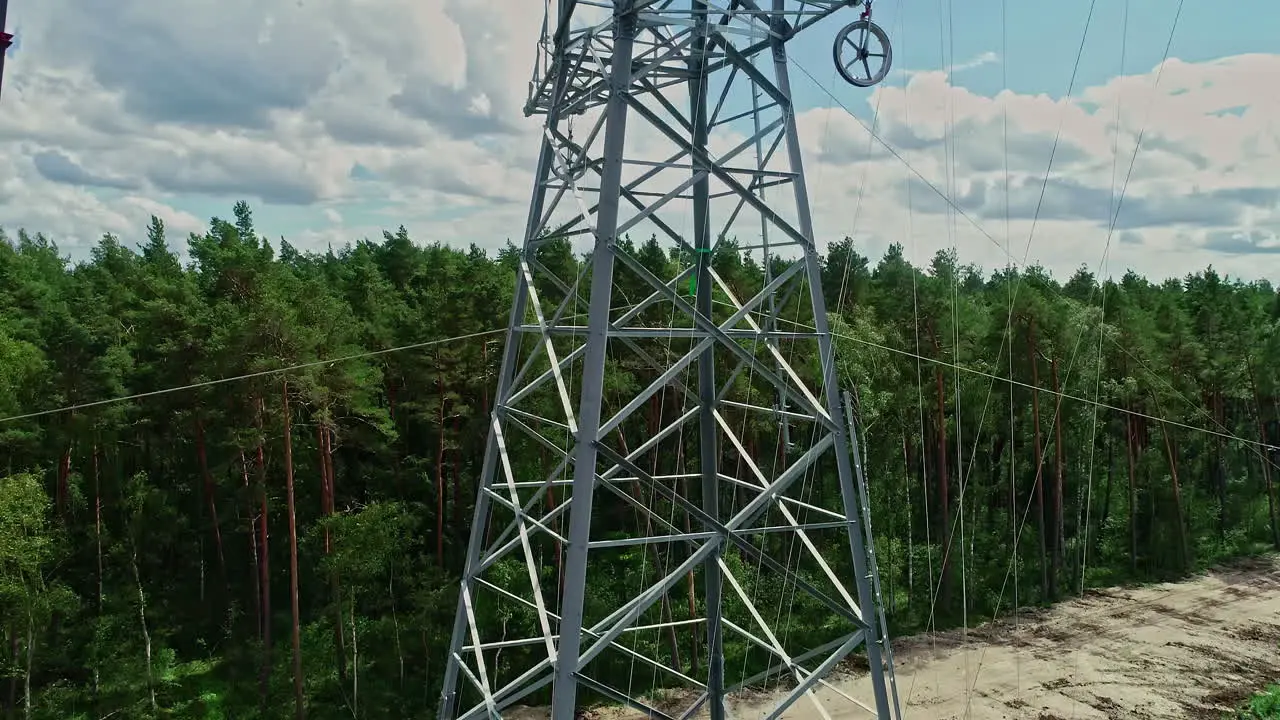 Rising Drone shot of Powerline Workers inspecting the power line tower for damage