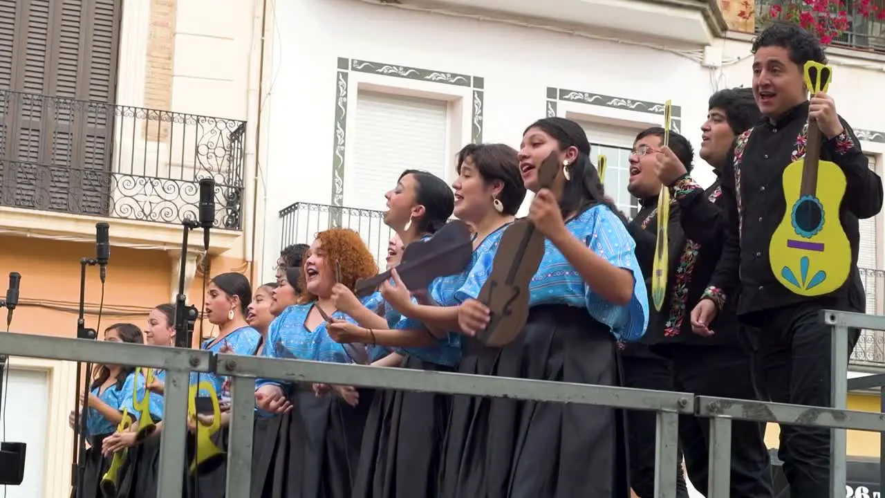 Side view of Mexican choir group singing on a stage outdoors