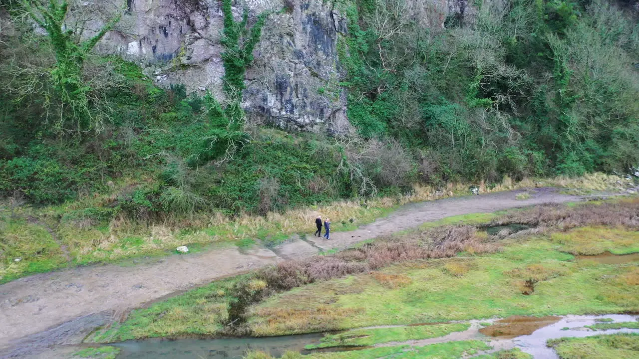 Aerial shot of two people walking along a path in the countryside