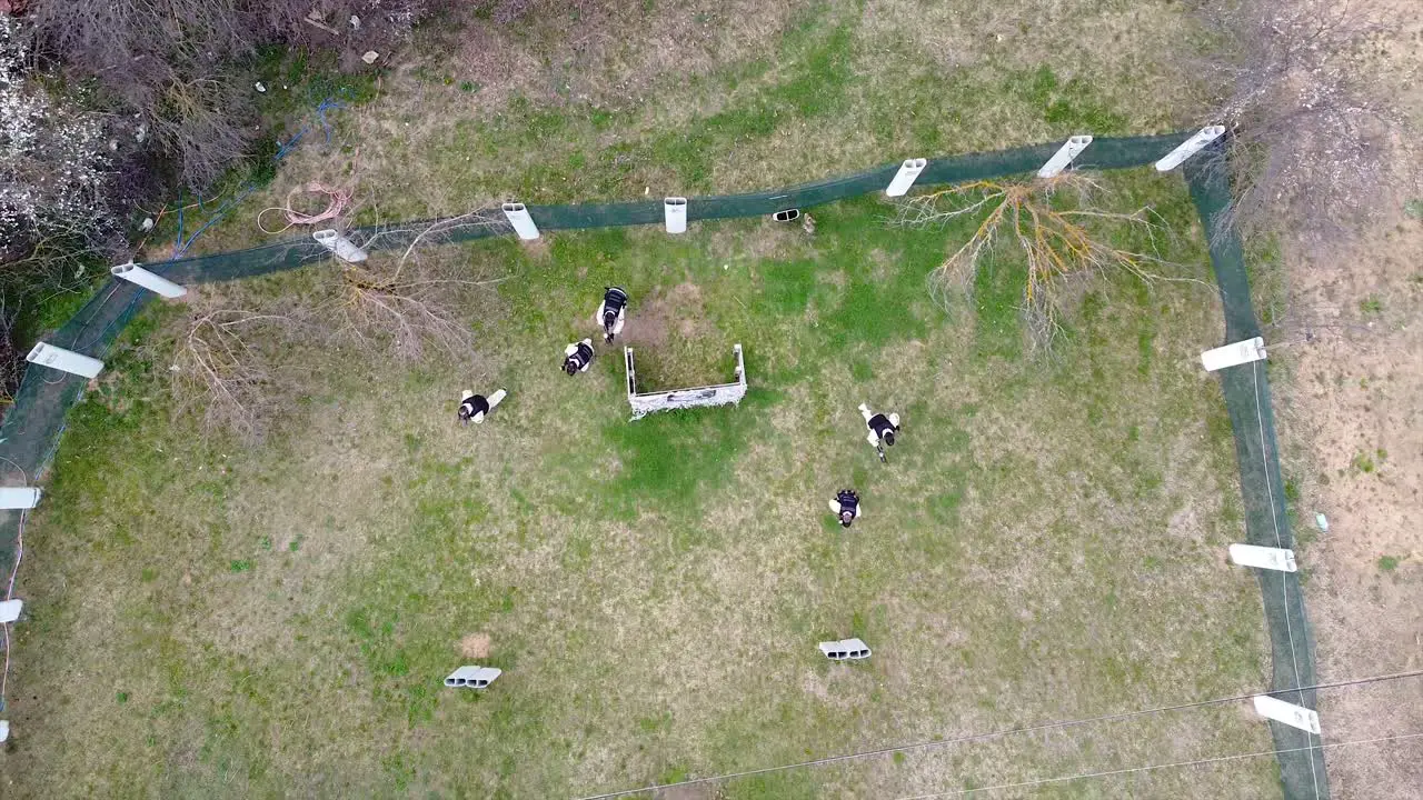 Paintball players spread out in formation at the start of a match drone shot