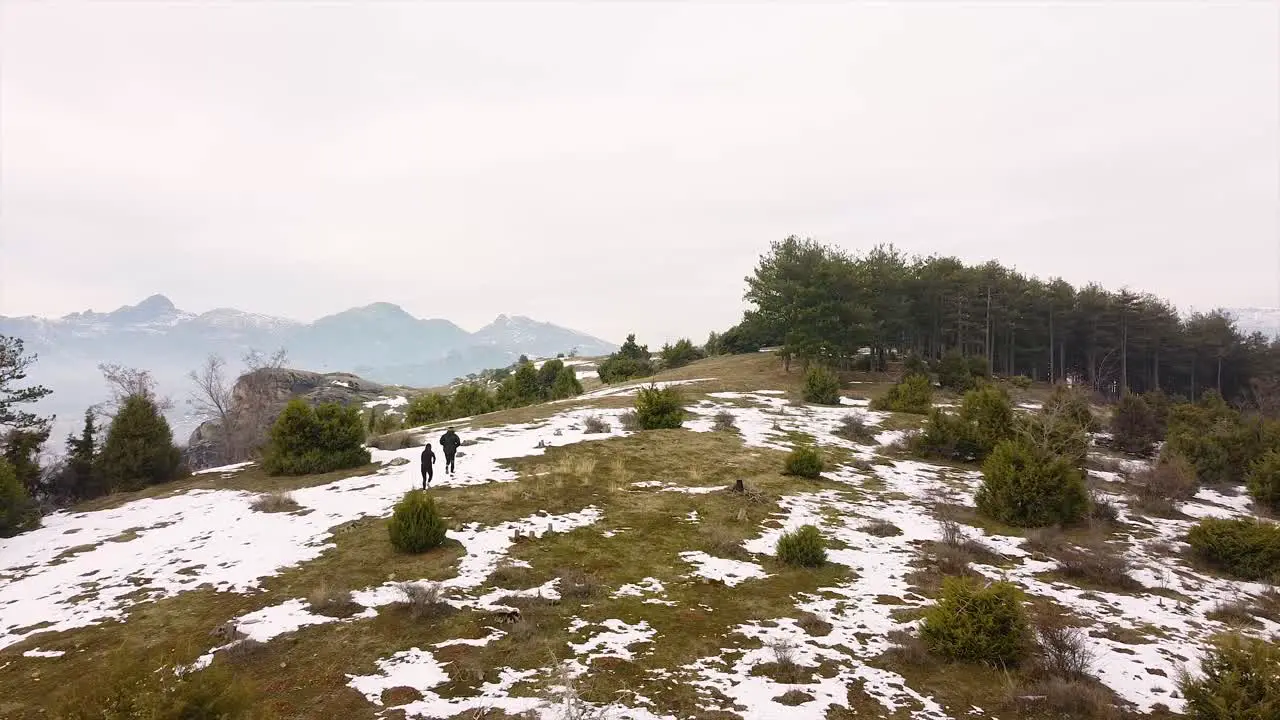 Athletes running in the mountains in winter drone shot