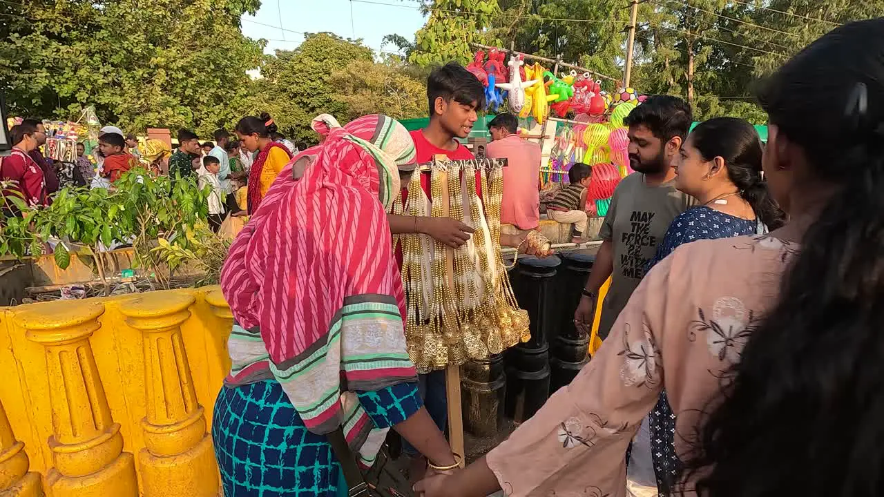 A woman is shopping for silver jewelery at Sweet Road with her husband