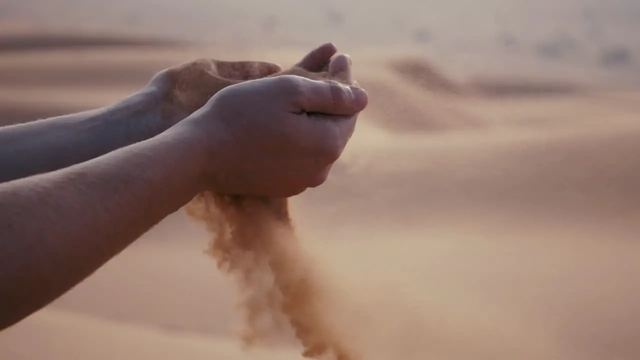 Women joyfully tossing sand in the desert