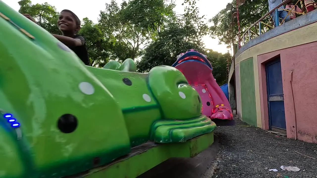 Family members with their children riding the thumping frog ride in an amusement park on holiday