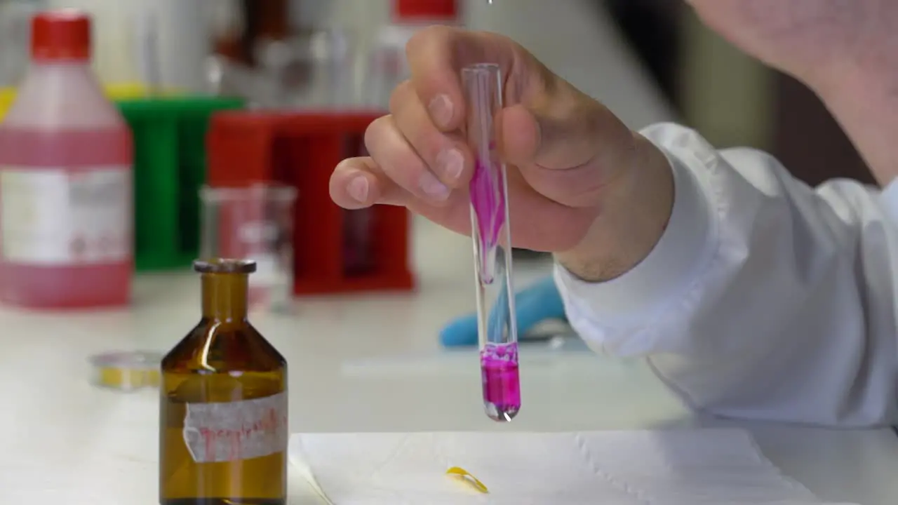 A chemist mixes chemical in a test tube at the lab