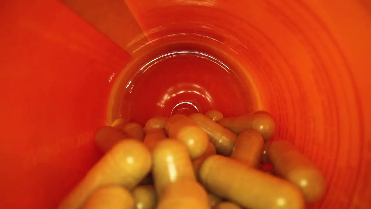 pulling out of the entire length of a orange supplement pill bottle revealing bottle's cap