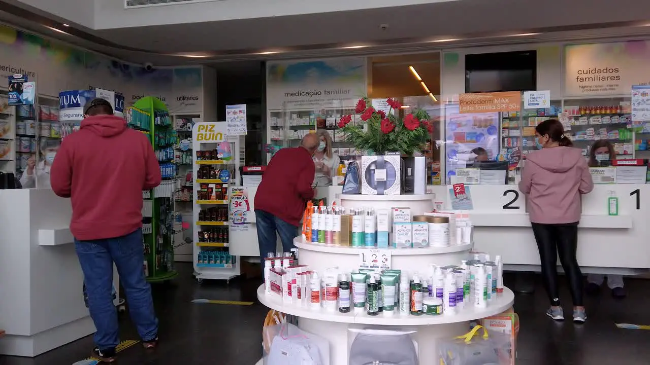 Back view of people with protective mask in local pharmacy