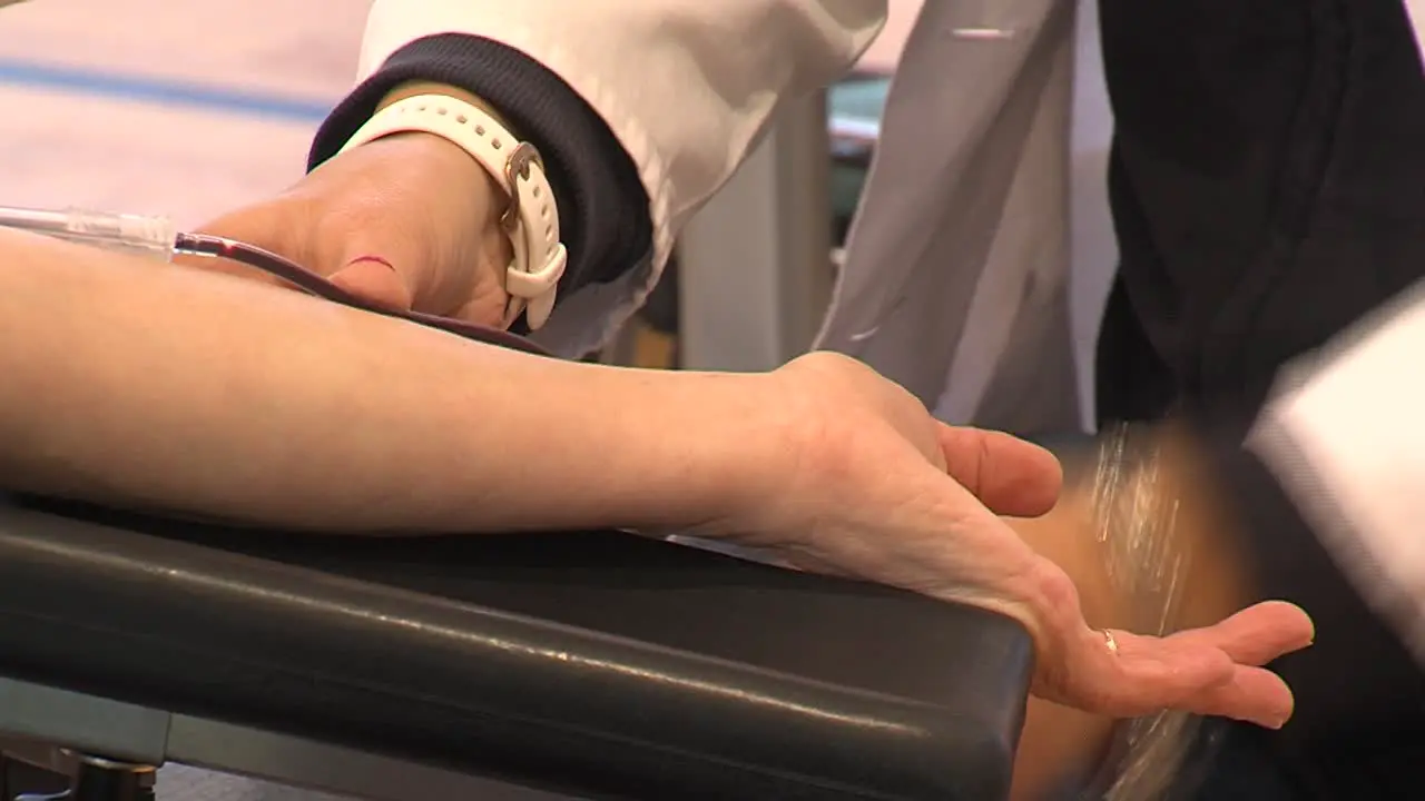 female nurse takes out transfusion needle from blood donor closeup static