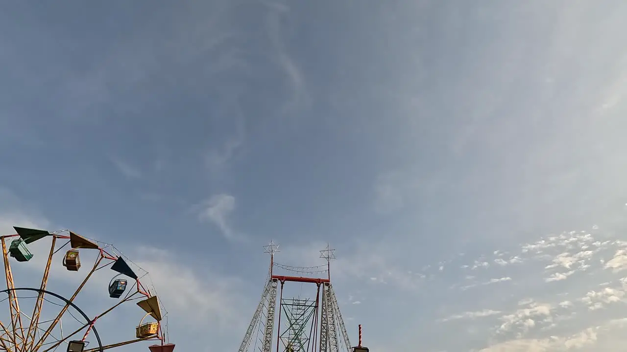 crocodile right scene during daytime which is going very high towards the sky and people are having fun with it