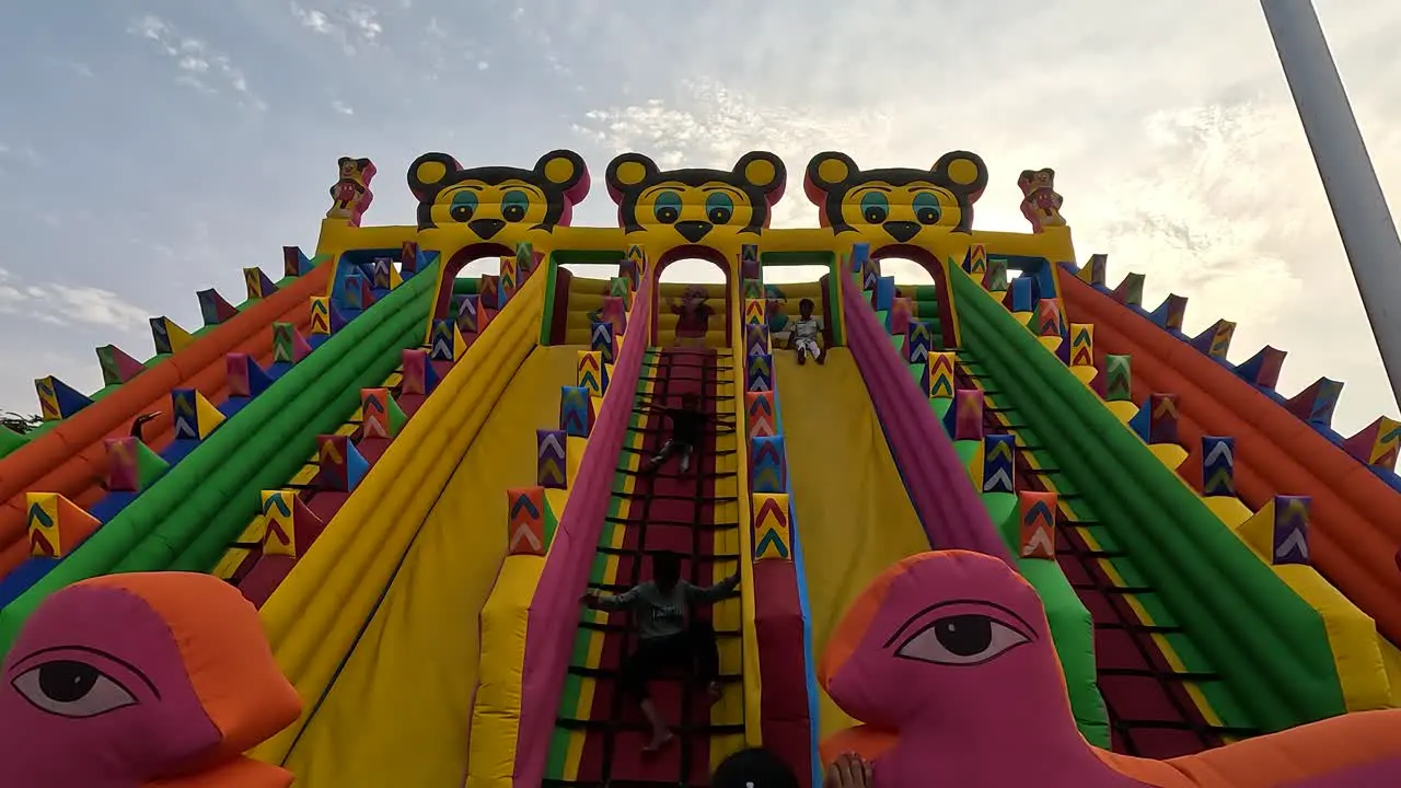 wide scene little kids are having fun sliding down the Mickey Mouse sliding rides