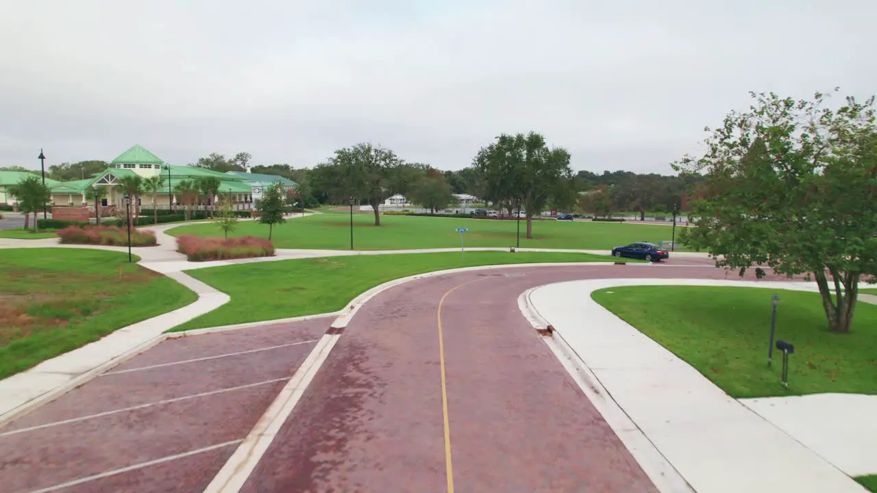 Aerial flyover of the charming and quaint city of Ocoee town hall brick roads and green space and Starke Lake in Central Florida