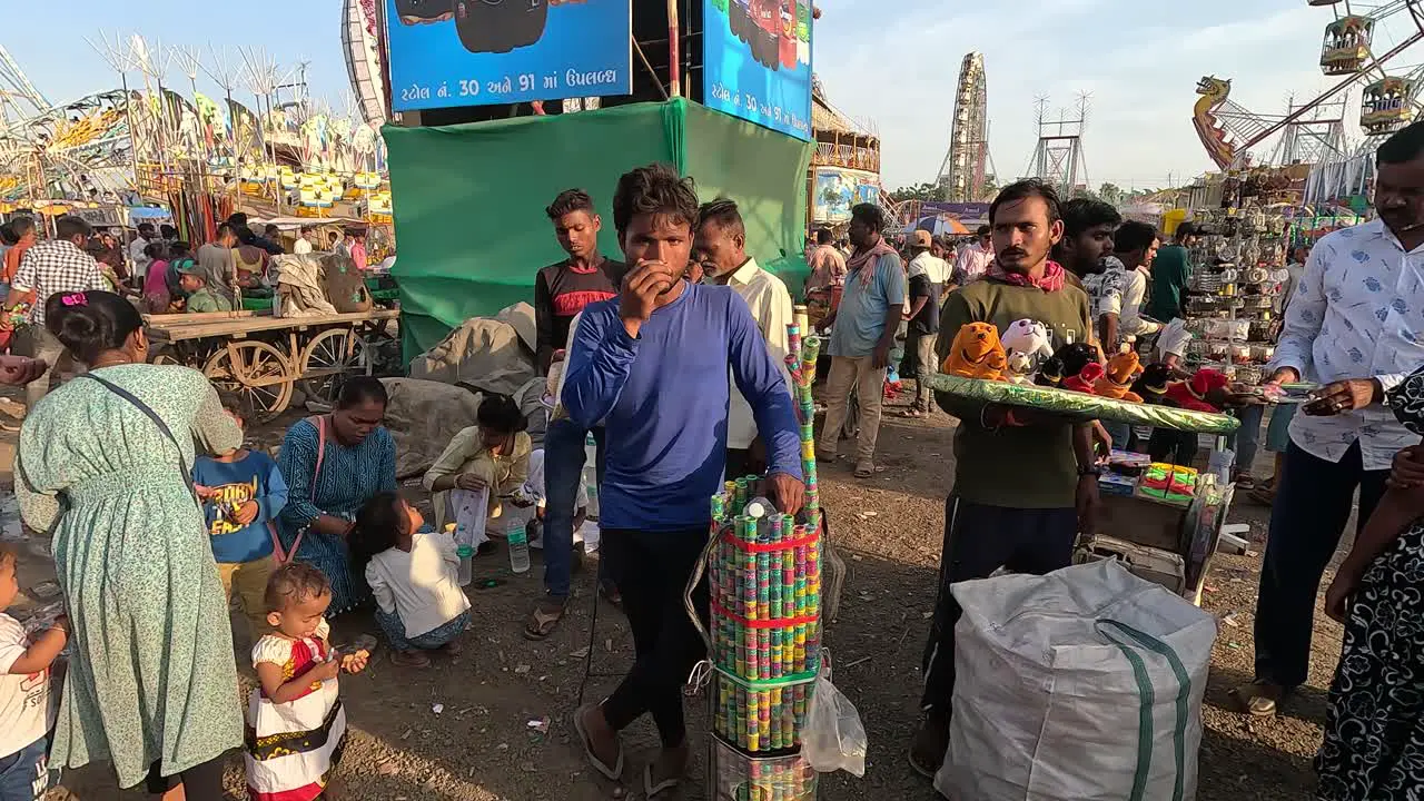 At the amusement park small shopkeepers are standing on the road selling toys