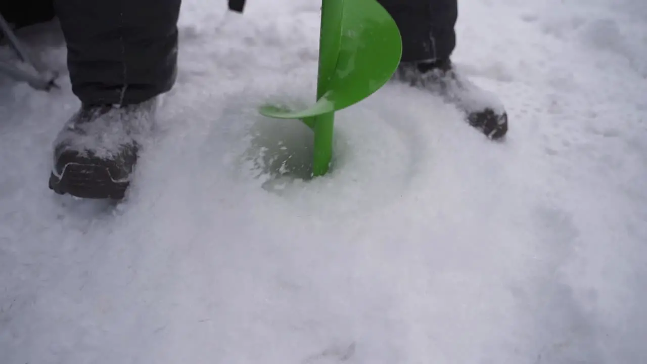 Man Drilling On Ice Using Auger Drill Ice Fishing At Sodus Bay In Winter