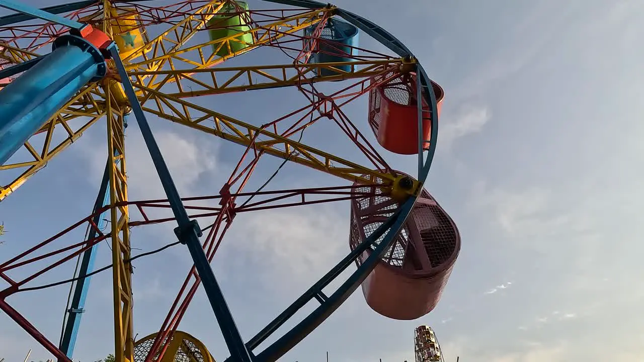 A scene of a colorful seating cart with people enjoying the ride in an amusement park