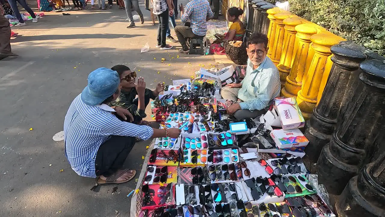 A shopkeeper is selling goggles glasses on the street road