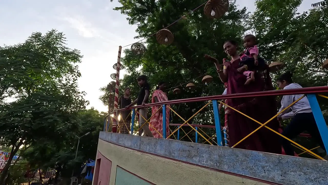 People are walking in the amusement park and going over the bridge during the holidays