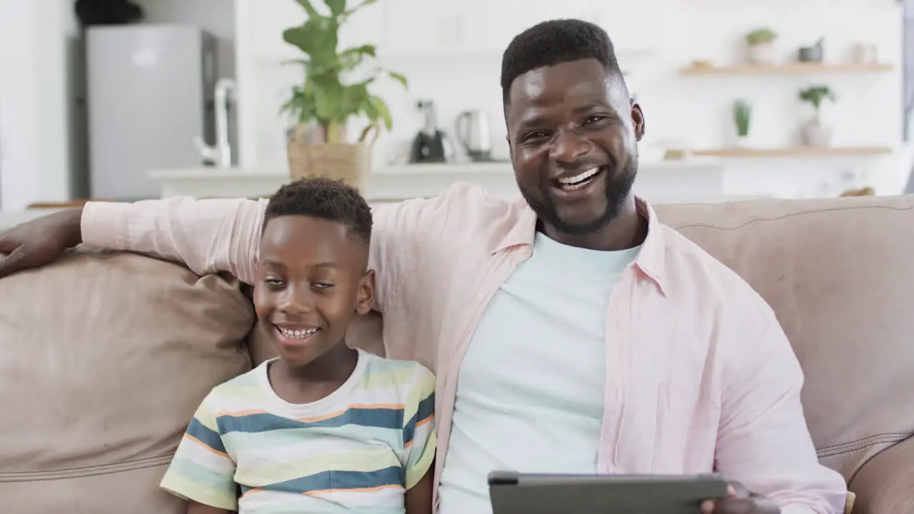 African American father and son smile in a home setting