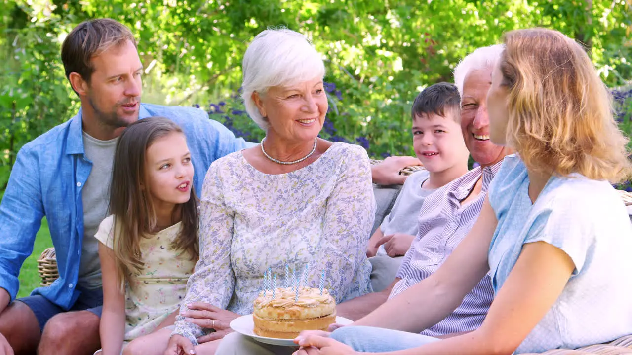 Three generation family celebrating a birthday in the garden