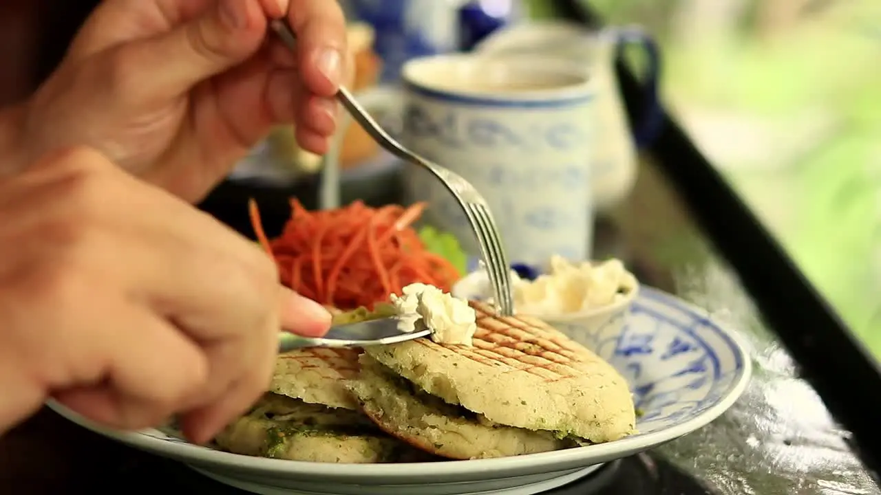 Close up to a vegan panini being topped with coconut cream for a healthy breakfast