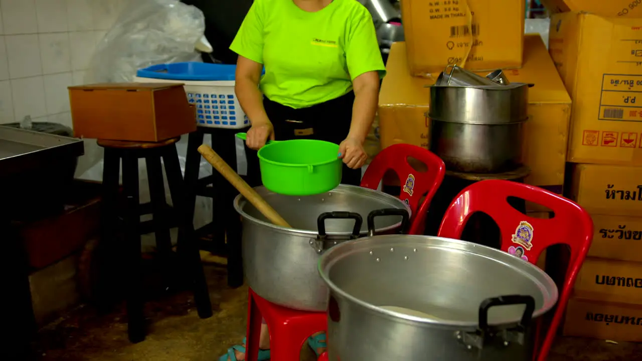 Thailand Bangkok 13 August 2022 Couple of workers filtering coconut water in the making of coco jelly famous thai street food