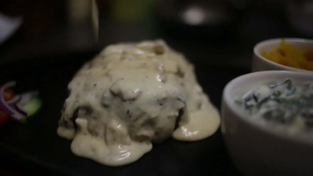 mushroom sauce drizzled over a steak in a dark restaurant setting