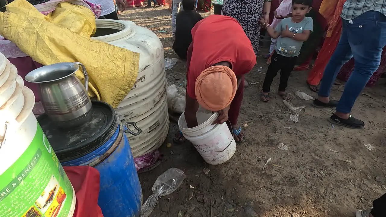 A person is washing a plastic bucket with water