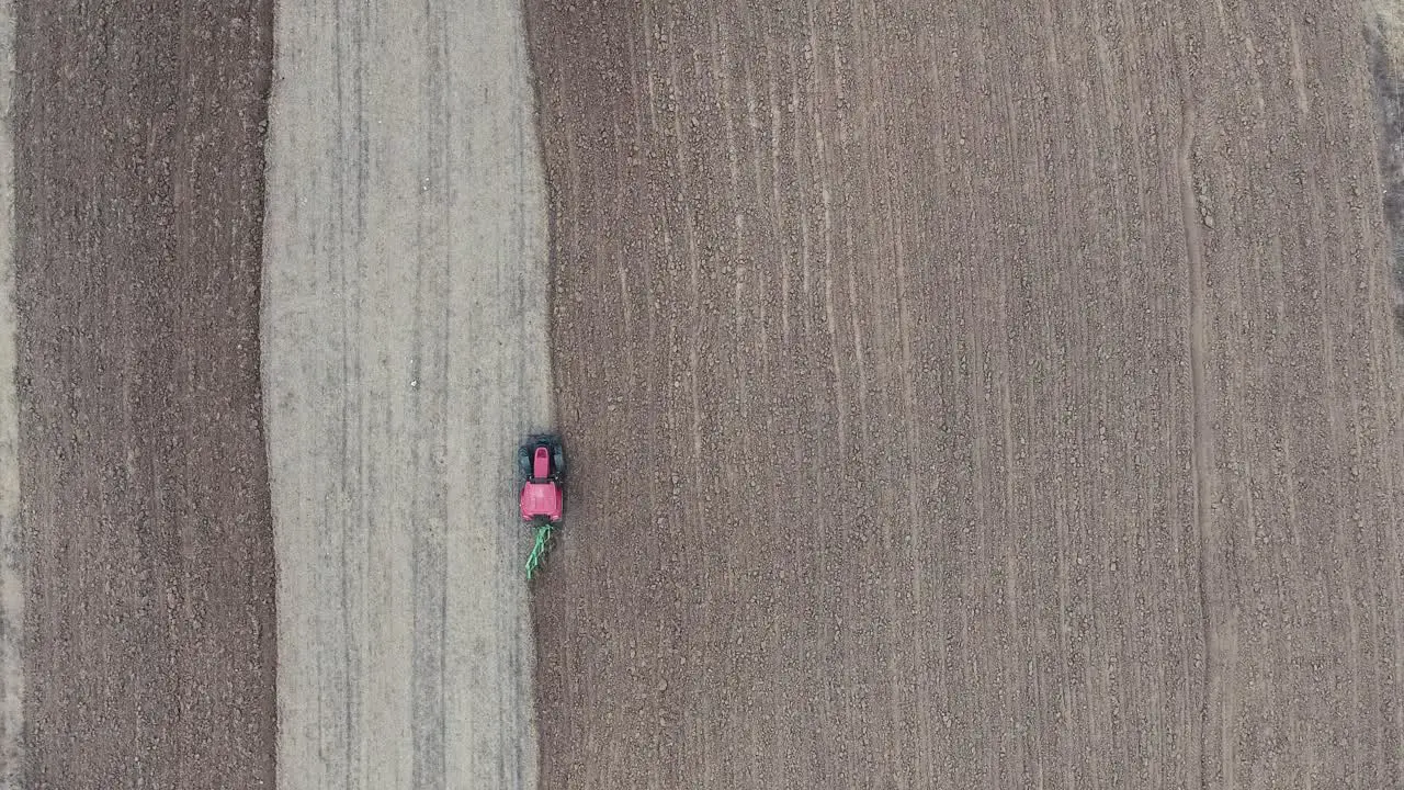 A red tractor plowing the field