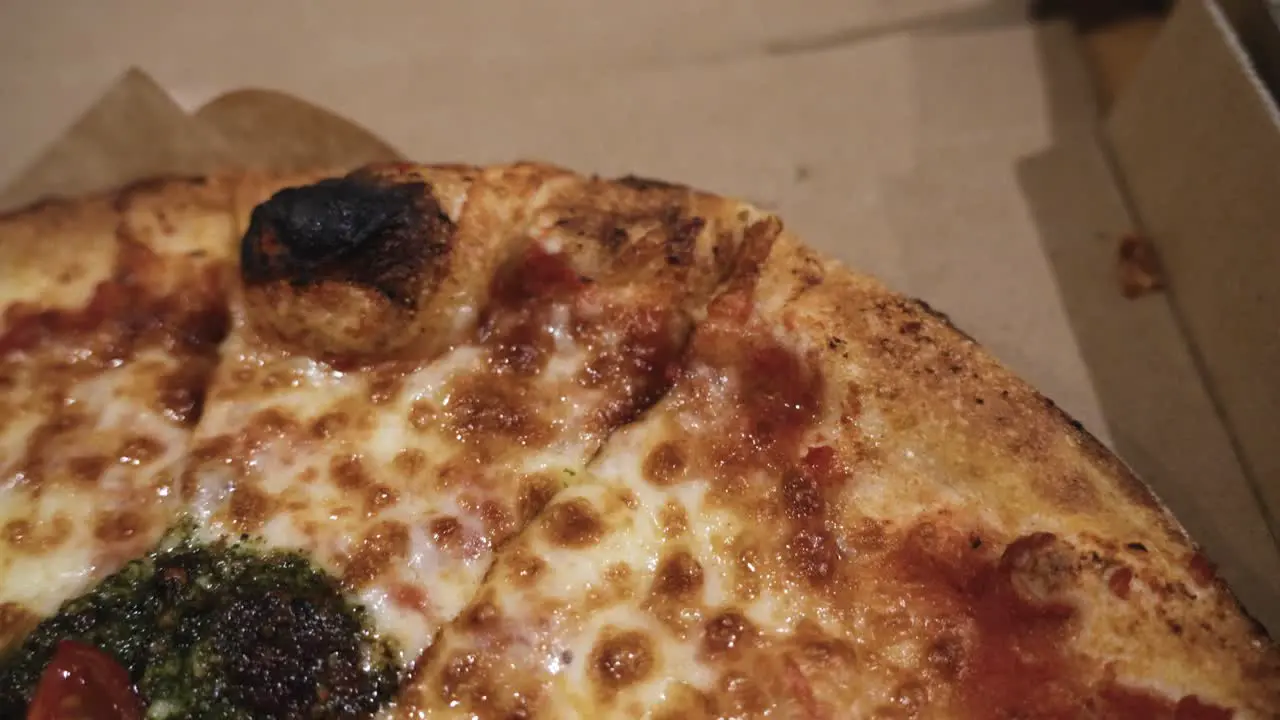 close up shot of delicious Italian pizzas delivered in boxes on the wooden table at home zooming out