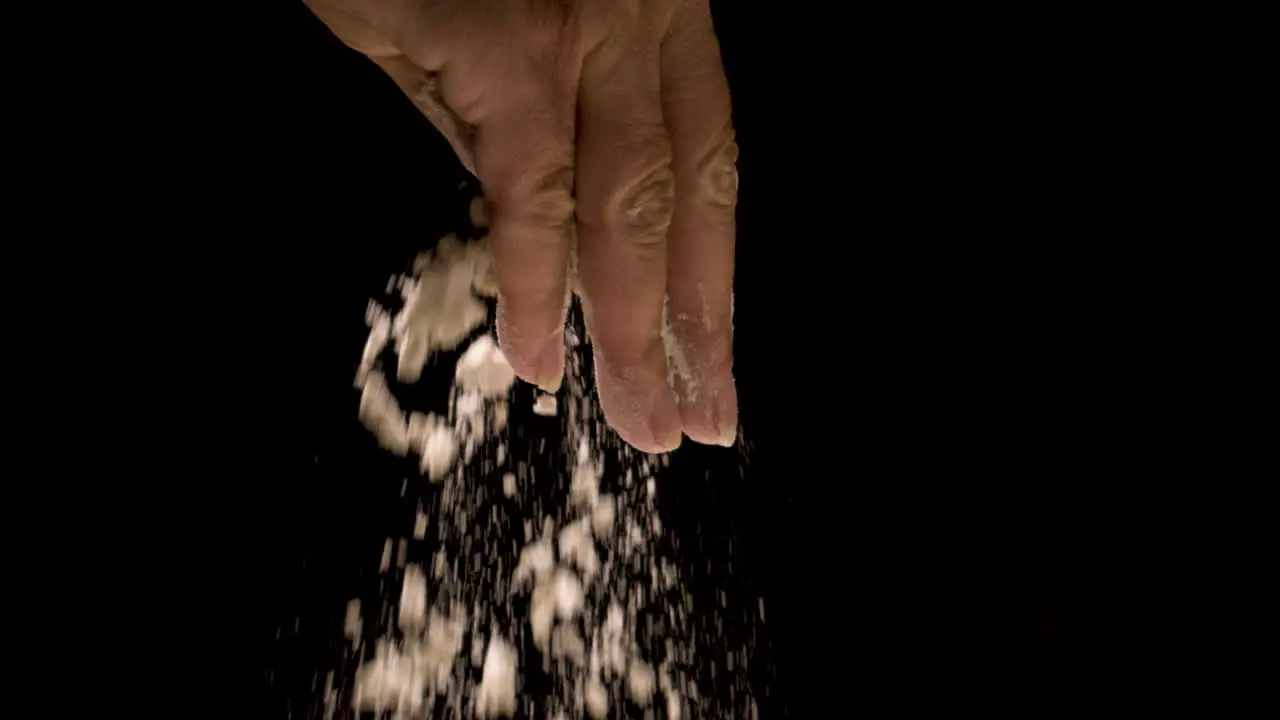 Flour being sprinkled at super slow motion on a black backdrop