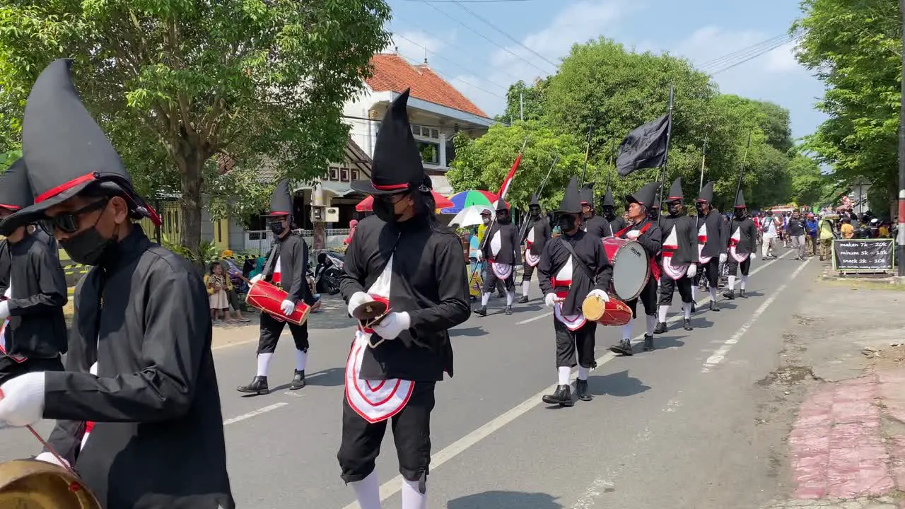 Rows of royal soldiers or Bregodo parade in historic costumes during the celebration of the founding of the city of Bantul while carrying musical instruments