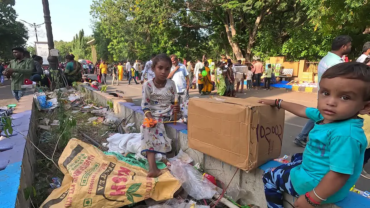 Outside the fair two laborers' children are selling toys on the street road