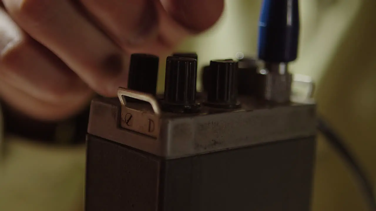 Tuning or setting old walkie talkie extreme closeup of finger and knobs