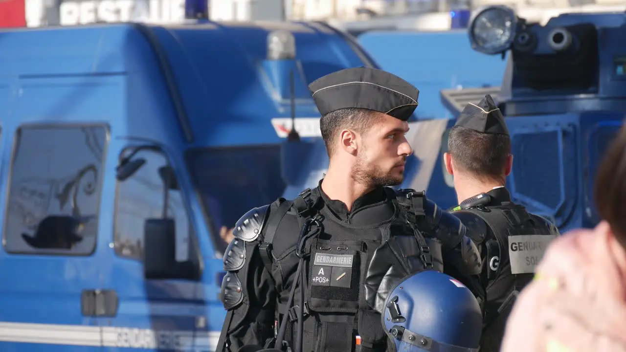 Police officers in full riot gear in front of blue police tanks in the middle of the street before a demonstration in Marseille south of France