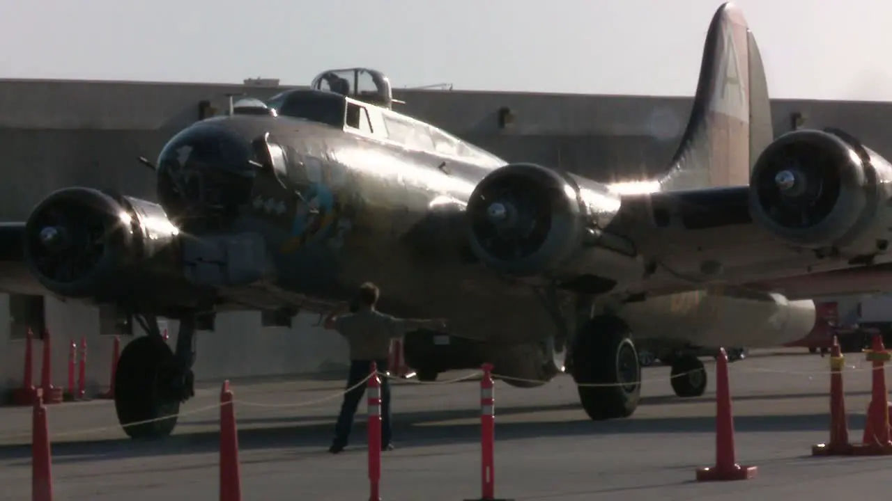 Airport personnel direct a vintage airplane