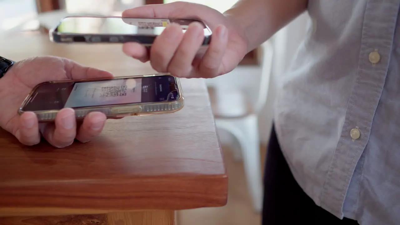 Friends using smartphone for payment at cafe restaurant for split payment